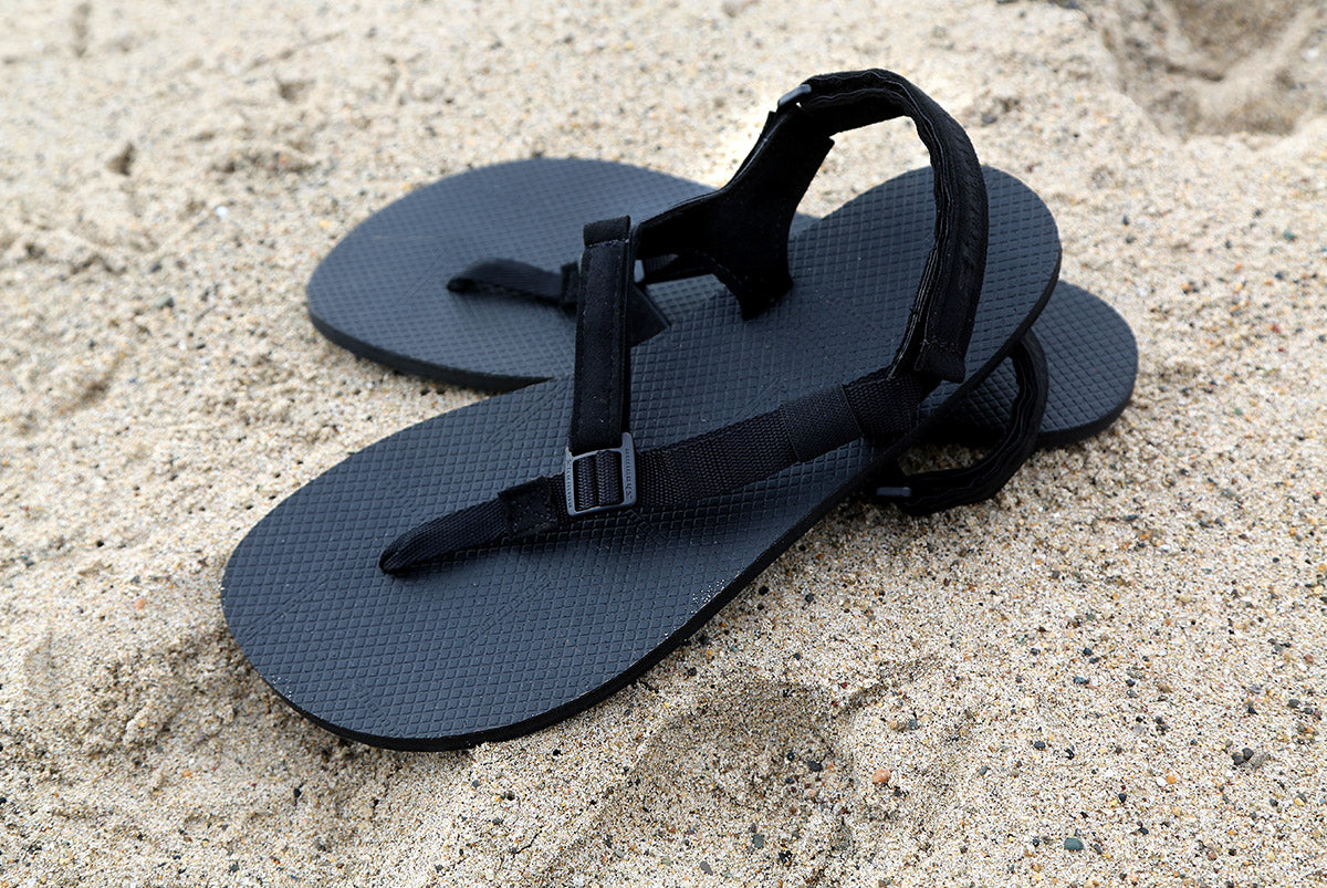 Black Chargers sandals on sand