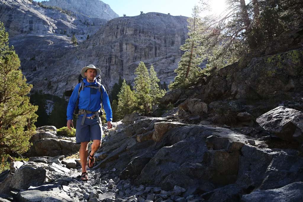 A man hiking through the mountains wearing Shamma Mountain Goats.